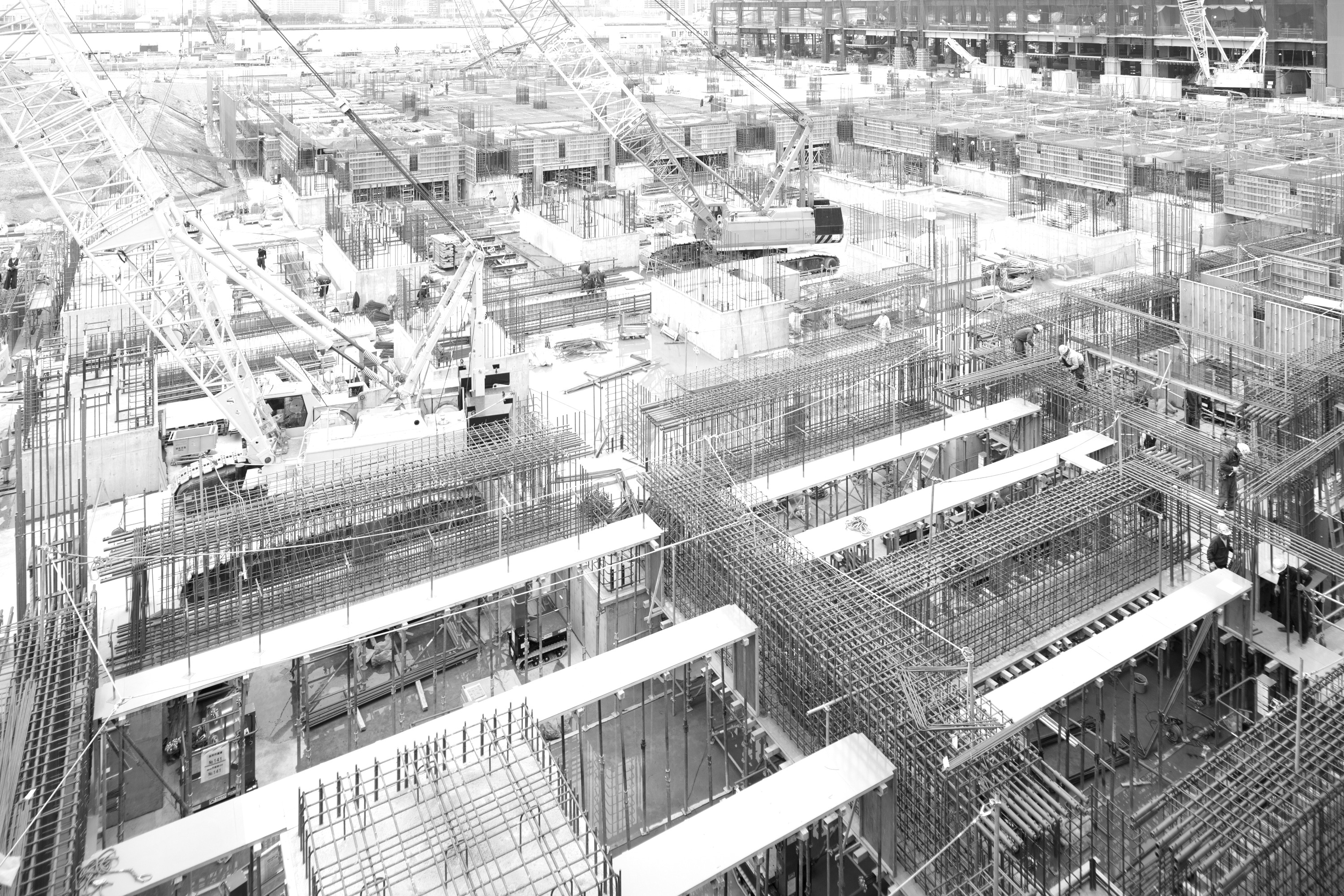 Estruturas de concreto, armaduras e gruas em um grande canteiro de obras